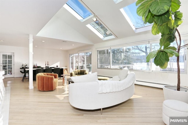 living room featuring lofted ceiling with skylight, light wood-type flooring, and baseboard heating