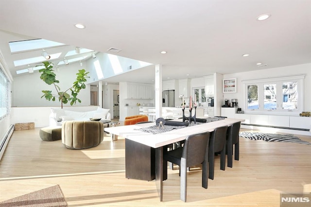 dining space with lofted ceiling and light wood-type flooring