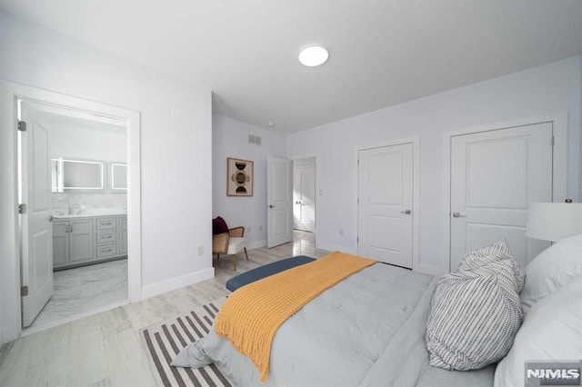 bedroom featuring sink and ensuite bath