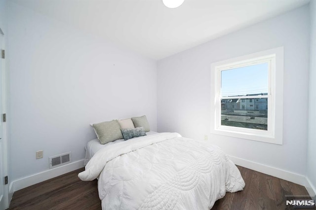 bedroom with dark hardwood / wood-style floors