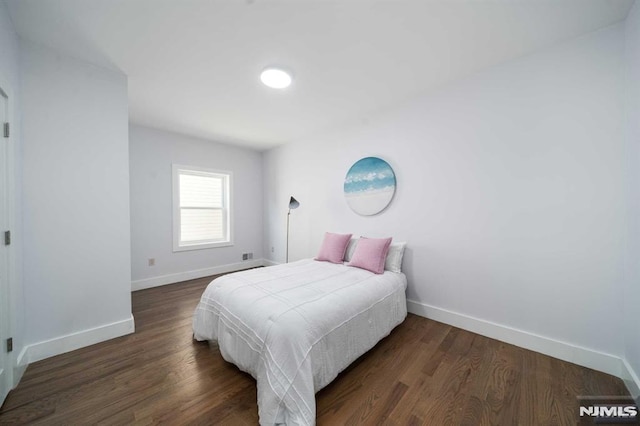 bedroom with dark hardwood / wood-style flooring