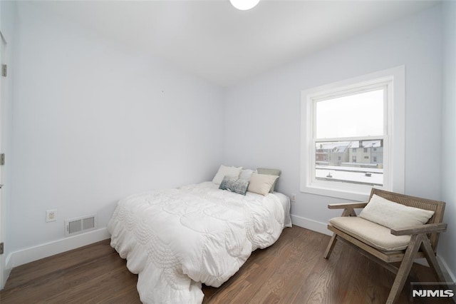 bedroom with dark wood-type flooring