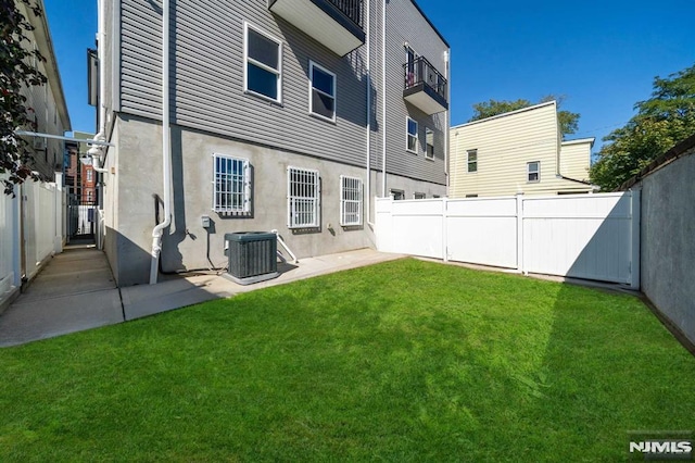 back of property with a yard and central air condition unit