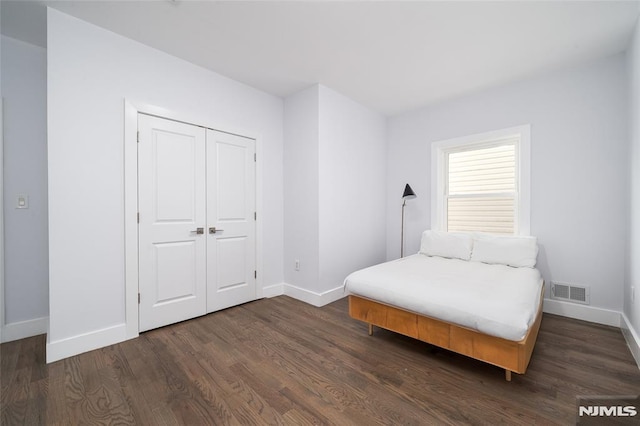 bedroom featuring dark hardwood / wood-style flooring and a closet