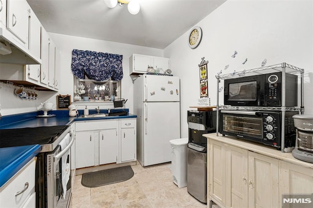 kitchen with white refrigerator, sink, stainless steel electric range, and white cabinets