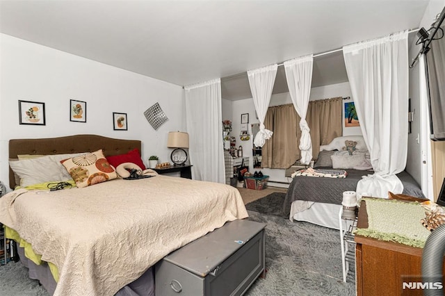 bedroom with carpet floors and baseboard heating