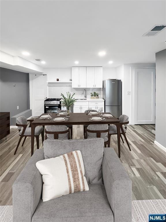 living room with sink and light hardwood / wood-style floors