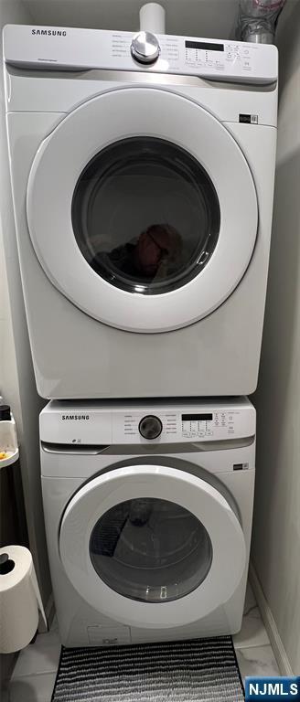 laundry area with stacked washing maching and dryer