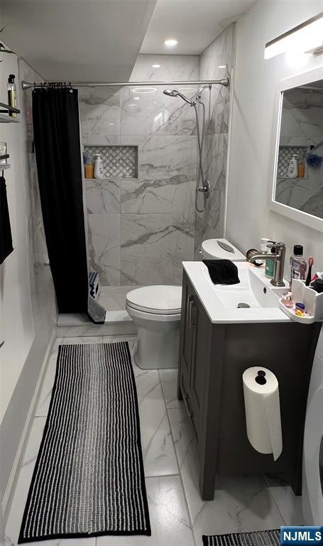 bathroom featuring vanity, washer / dryer, toilet, and a shower with shower curtain