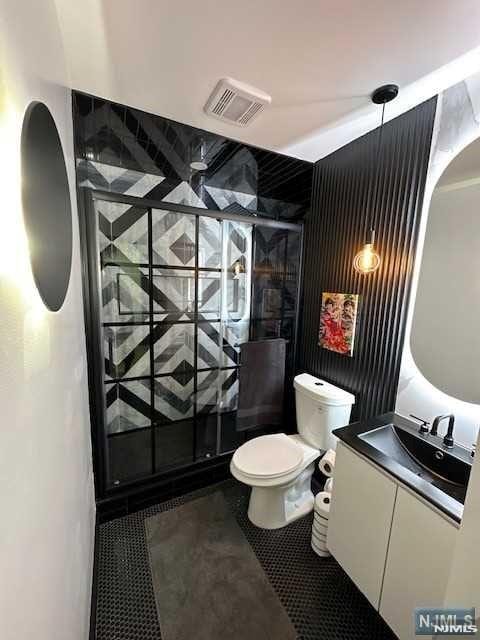 bathroom with vanity, toilet, and walk in shower