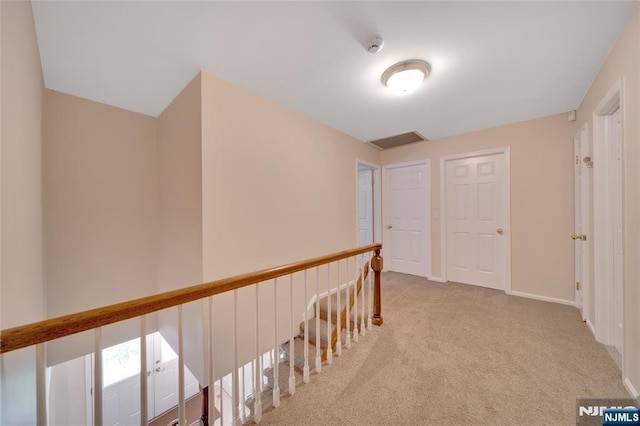 corridor with visible vents, baseboards, and carpet