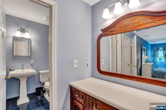 bathroom featuring tile patterned floors, visible vents, toilet, and a sink