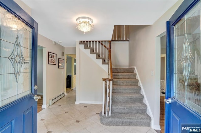 foyer featuring stairway, baseboards, baseboard heating, and light tile patterned flooring