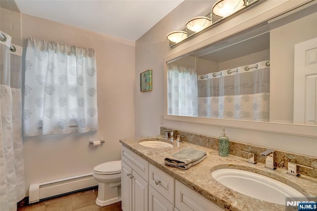 bathroom with a sink, double vanity, toilet, and a baseboard radiator