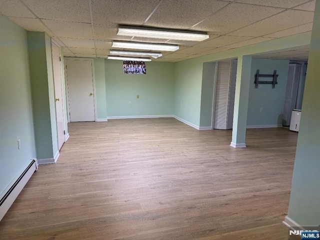 spare room featuring baseboards, baseboard heating, and wood finished floors