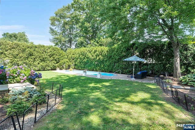 view of yard featuring an outdoor pool, a patio, and fence