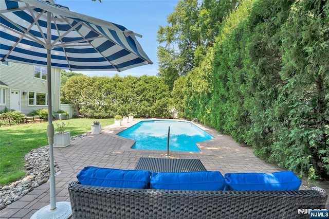 outdoor pool with a patio, a yard, and an outdoor hangout area