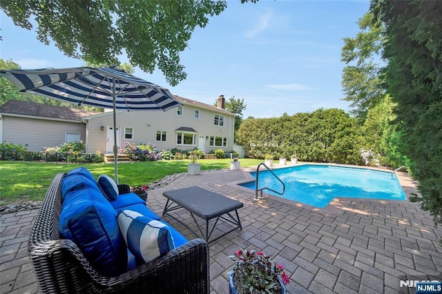 outdoor pool with a yard, an outdoor hangout area, and a patio area