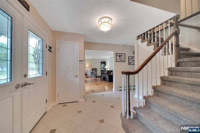 foyer entrance featuring light tile patterned flooring, stairway, baseboards, and a baseboard radiator