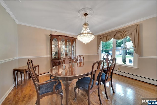 dining room featuring a notable chandelier, ornamental molding, wood finished floors, baseboards, and baseboard heating