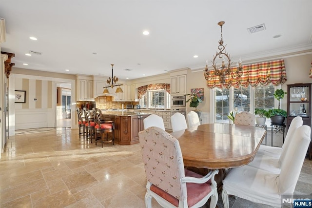 dining room with ornamental molding and a chandelier