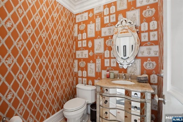 bathroom featuring ornamental molding, vanity, and toilet