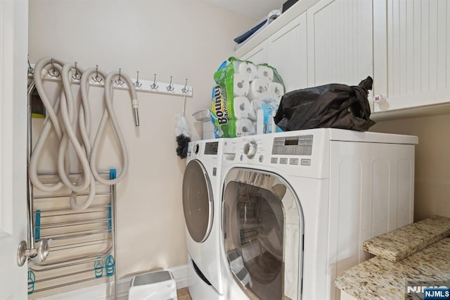 washroom with cabinets and washing machine and dryer