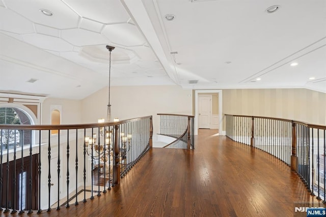 corridor featuring hardwood / wood-style flooring, ornamental molding, and an inviting chandelier