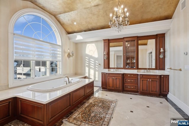 bathroom featuring vanity, a chandelier, and a tub