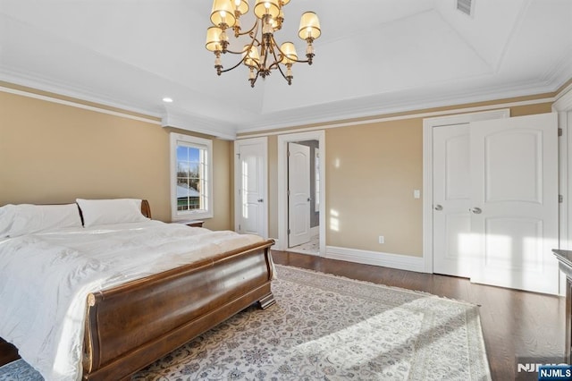 bedroom with crown molding, dark hardwood / wood-style floors, a notable chandelier, and a tray ceiling