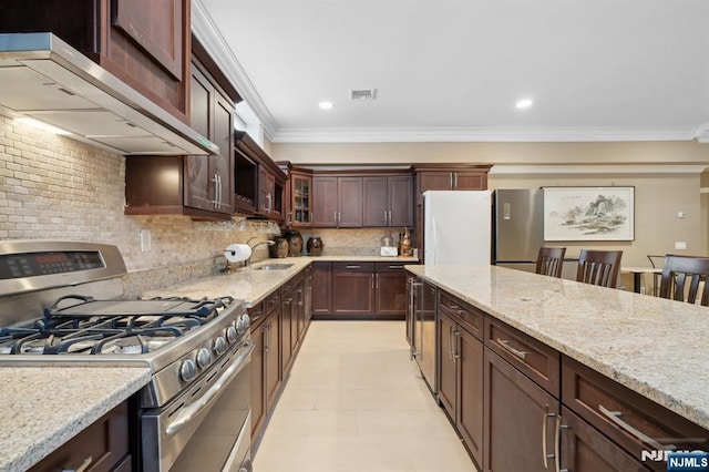 kitchen featuring sink, appliances with stainless steel finishes, backsplash, ornamental molding, and wall chimney exhaust hood