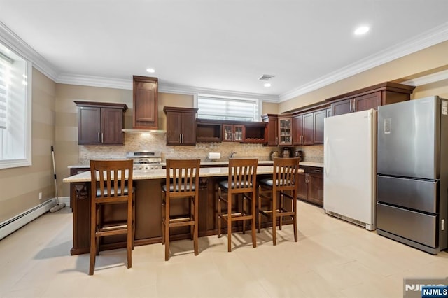 kitchen featuring stainless steel refrigerator, stove, a center island, white refrigerator, and ornamental molding