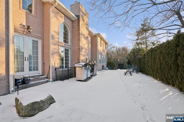 view of snow covered exterior with french doors