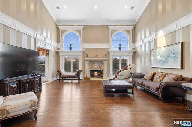 living room with ornamental molding, a wealth of natural light, and dark hardwood / wood-style flooring