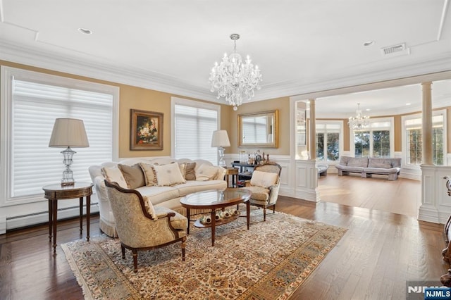 living room featuring ornate columns, a baseboard radiator, ornamental molding, and a notable chandelier