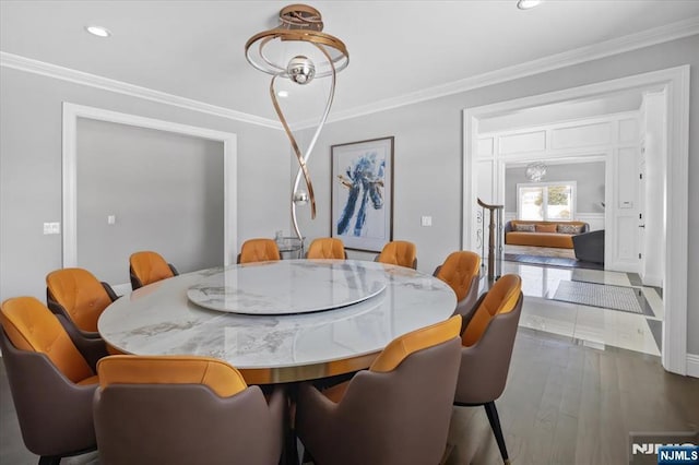 dining room with ornamental molding and hardwood / wood-style floors