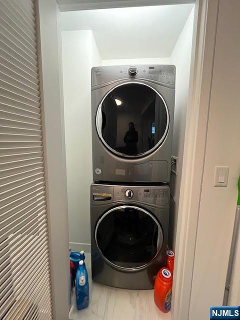 laundry room featuring stacked washer / drying machine