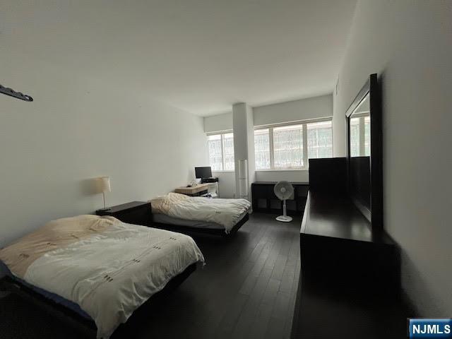 bedroom with dark wood-type flooring