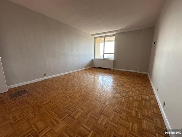 unfurnished room with parquet flooring