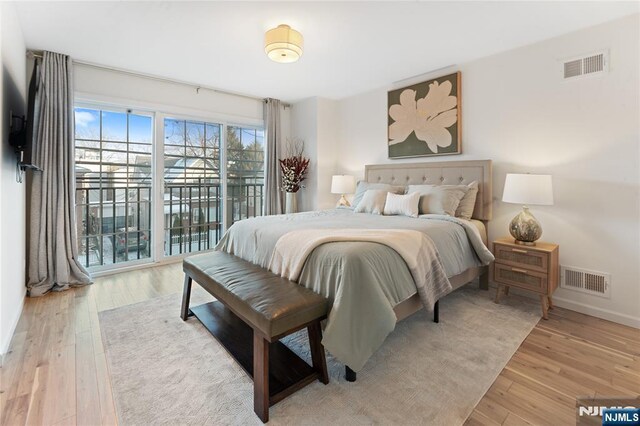 bedroom featuring access to exterior and light hardwood / wood-style flooring