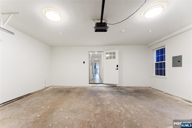 garage with a garage door opener and electric panel