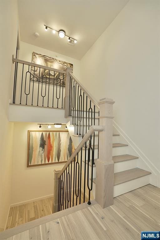 staircase with hardwood / wood-style flooring