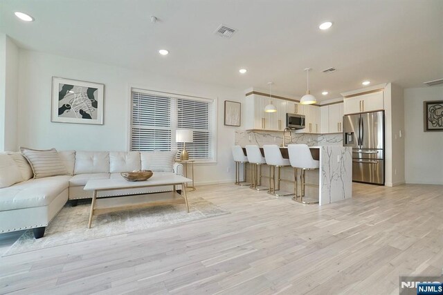 living room with sink and light wood-type flooring