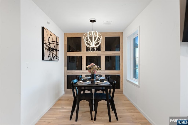 dining room with an inviting chandelier and light wood-type flooring