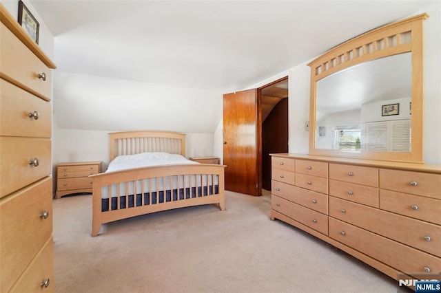 bedroom with light colored carpet and vaulted ceiling