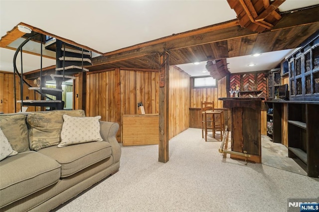 living room with bar area, light carpet, and wood walls