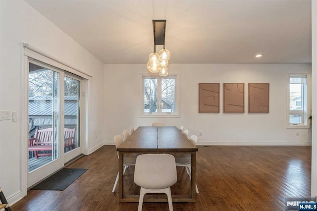 dining room with an inviting chandelier and dark wood-type flooring