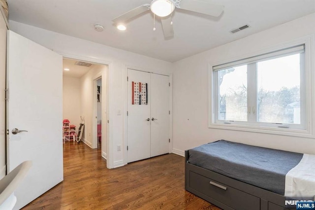 bedroom featuring dark hardwood / wood-style flooring, a closet, and ceiling fan