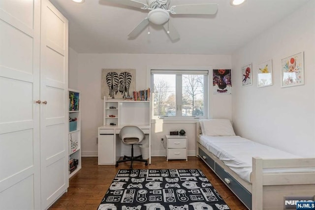 bedroom featuring dark wood-type flooring, ceiling fan, and a closet