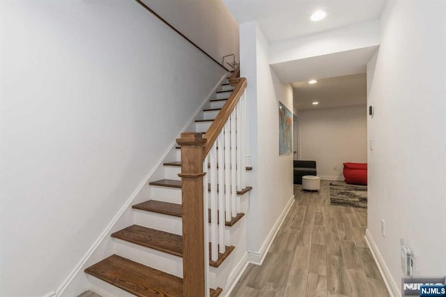 staircase with hardwood / wood-style floors